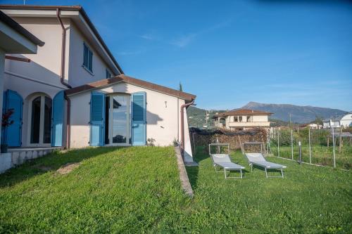 twee stoelen op een gazon naast een huis bij Casa Grotti: Charm & Comfort vicino al Mare in Capezzano Pianore,