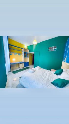 a bedroom with a large bed with a green wall at JCK Tuscany Apartment in Livorno