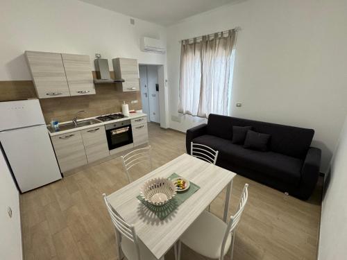 eine Küche und ein Wohnzimmer mit einem Tisch und einem Sofa in der Unterkunft B&B CARLO e ANNA in Ottava Sassari