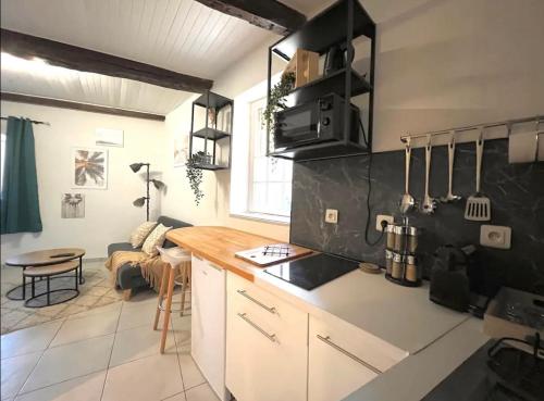 - une cuisine avec un comptoir et une table dans une pièce dans l'établissement Le Viala, Studio dans le centre historique de Hyères, à Hyères