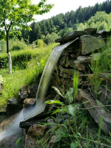 a stream of water coming out of a stone wall at Ljetna bašta "LISIN"Bradina Konjic in Konjic