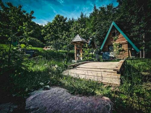 a wooden bridge with a gazebo in front of a cabin at Ljetna bašta "LISIN"Bradina Konjic in Konjic