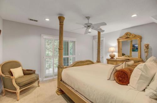 a bedroom with a bed and a mirror and a chair at Fairway Oaks 42 by Wild Dunes, Home Close to Resort Core with Amenity Access in Isle of Palms