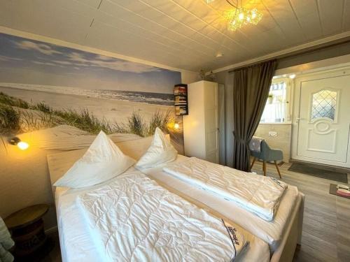 een slaapkamer met een bed en een schilderij van een strand bij Villa Hügel Comfortable holiday residence in Heiligenhafen