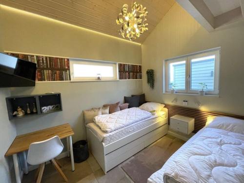 1 dormitorio con cama, escritorio, cama y ventana en My holiday home Zanzibar, en Hohwacht