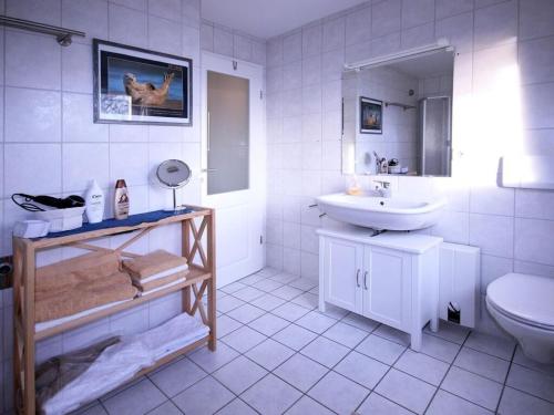 オルデンブルクにあるHoliday Apartment 2 Oldenbugの白いバスルーム(洗面台、トイレ付)