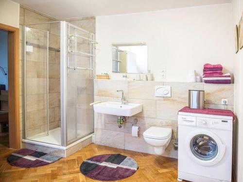 een badkamer met een douche, een wastafel en een wasmachine bij Your temporary home in Oldenburg in Oldenburg