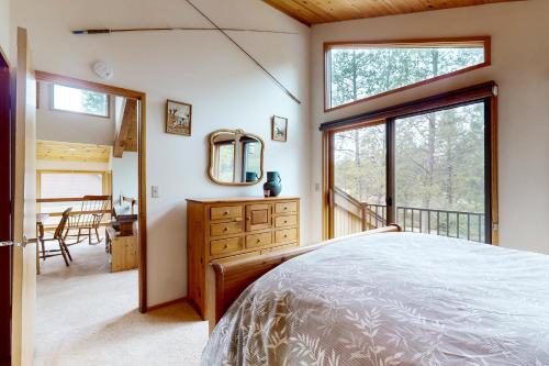 a bedroom with a bed and a large window at Golden Eagle Lane 17 | Discover Sunriver in Sunriver