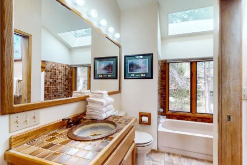 a bathroom with a sink and a toilet and a mirror at Golden Eagle Lane 17 | Discover Sunriver in Sunriver
