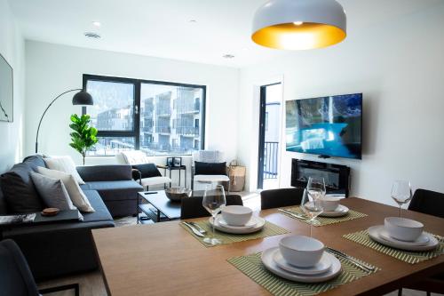 a living room with a table and chairs and a couch at Birdies and Bears by Revelstoke Vacations in Revelstoke