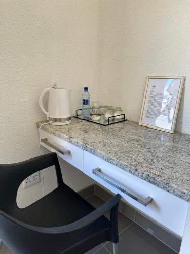 a desk with a chair and a bottle of water on it at Mikan AirBnB in Otjiwarongo