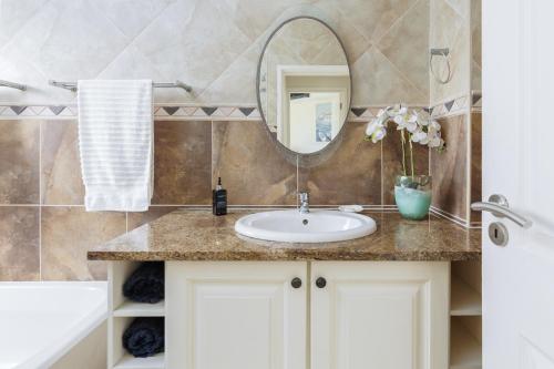 a bathroom with a sink and a mirror at Lucien Sands 602 in Margate
