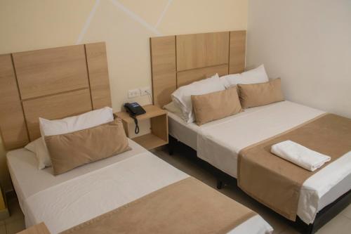 Habitación de hotel con 2 camas y teléfono en Hotel Central, en Sincelejo