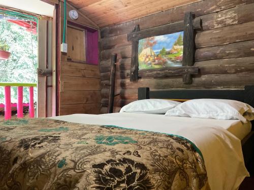 a bedroom with a bed in a log cabin at Cabañas el Portal in Santa Rosa de Cabal