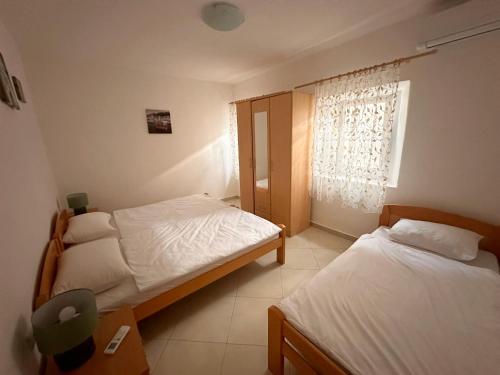 een slaapkamer met 2 bedden en een raam bij Holiday Home Nautica in Kotor