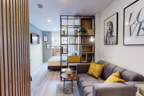een woonkamer met een bank en een slaapkamer bij gAº Ideal apartamento en Cabrera in Bogota