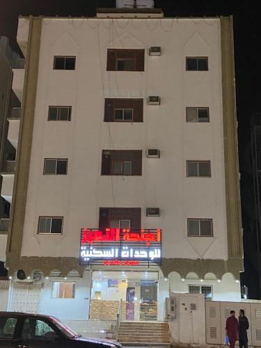 a building with a sign in front of it at اجنحة التميز للوحدات السكنية in Medina