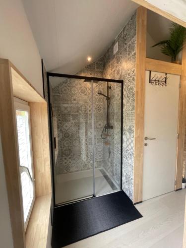 een douche met een glazen deur in een kamer bij Le Petit Papillon in Durbuy