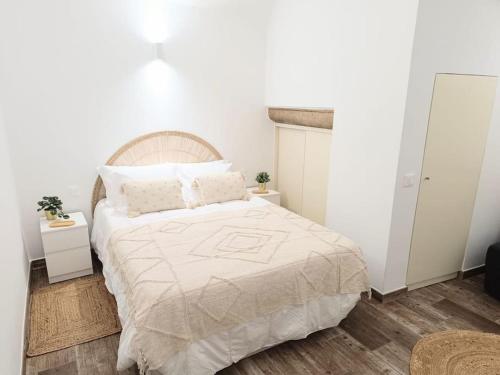 a bedroom with a large bed with white walls at Encantador T1 Coração de Évora in Évora