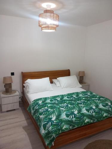 a bedroom with a bed with a green blanket at Terei-Here Bungalow Airport in Avae