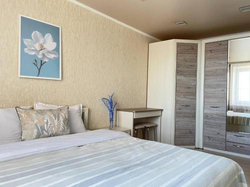 1 dormitorio con 1 cama y un dibujo floral en la pared en Seven City 24, en Semey