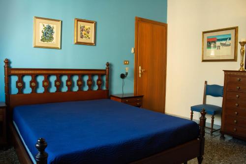 um quarto com uma cama e uma parede azul em Una rosa sul mare Monopoli em Monopoli