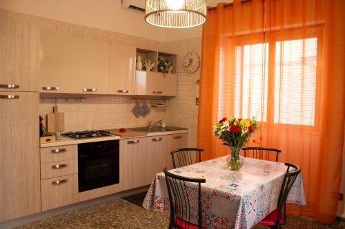 uma cozinha com uma mesa com um vaso de flores sobre ela em Una rosa sul mare Monopoli em Monopoli