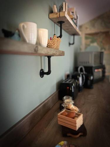 a kitchen with wooden floors and shelves with food on the floor at The Stables at Ballyward Croft in Ardkeen