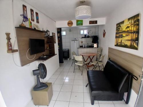 ein Wohnzimmer mit Sessel und Fernseher in der Unterkunft PORTO GALINHAS TODO MOBILIADO 5 minutos a pé da praia in Porto De Galinhas