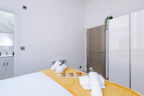 a white bedroom with a bed with towels on it at Modern 2-bedroom Apt In The Heart Of City Centre in Liverpool