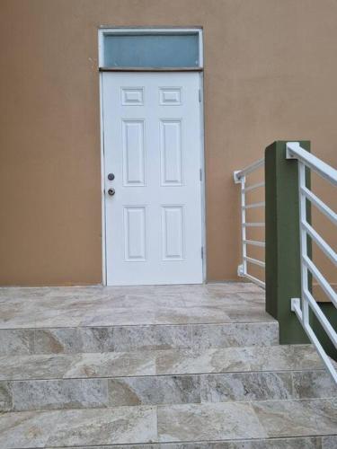 een witte deur aan de zijkant van een gebouw bij Spacious and Comfy 1 bdr 1 bth Great location in Long Swamp