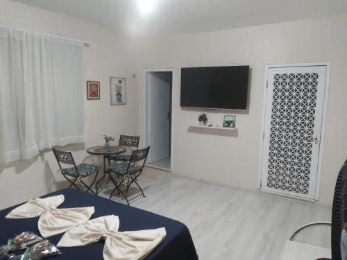 a living room with a table and a flat screen tv at Pousada Suítes Meireles in Fortaleza