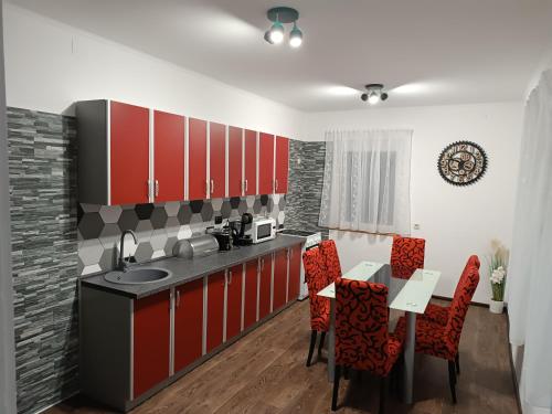 uma cozinha com armários vermelhos, uma mesa e cadeiras em Holiday Home Colnar em Brod na Kupi