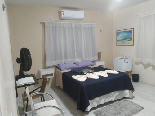 a bedroom with a bed with purple pillows and a chair at Pousada Suítes Meireles in Fortaleza