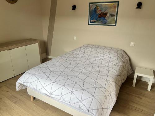 une chambre avec un lit et une chaise dedans dans l'établissement la veranda, à Fontenay-le-Pesnel