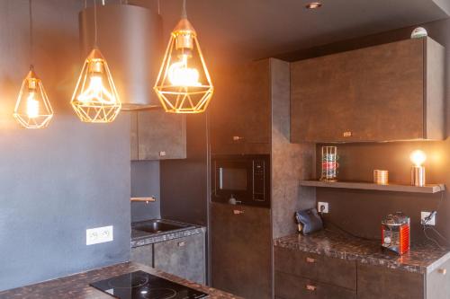 uma cozinha com várias luzes penduradas no tecto em appartement face mer em La Baule