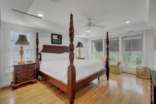 Schlafzimmer mit einem Bett, einer Kommode und Fenstern in der Unterkunft Yacht Harbor Court 7 in Isle of Palms