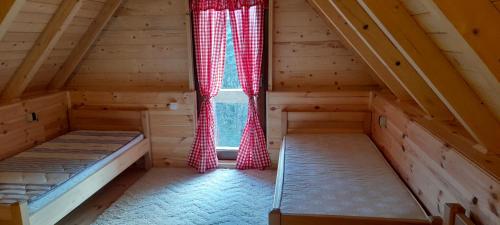 an attic room with two beds and a window at Weekend House Komovi-Kobildo in Kolašin