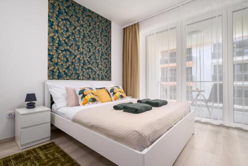 a bedroom with a white bed with a large window at NEW home by the Liget in Budapest