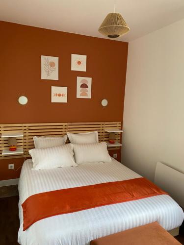een slaapkamer met een groot bed met oranje en witte lakens bij Le Colibri - Domaine de la Houblette in Challans