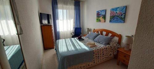 - une petite chambre avec un lit et une télévision dans l'établissement Apartamento Carmen, à Santa Pola