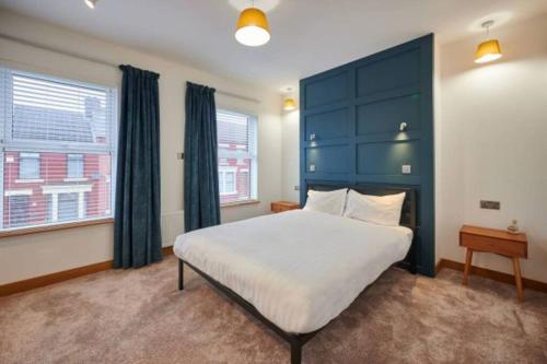 a bedroom with a large bed with a blue headboard at Home away from home in Liverpool
