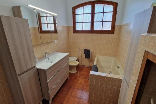 une salle de bain avec un lavabo, une baignoire et des toilettes dans l'établissement Grande maison climatisée piscine en bord de mer, à Saint-Cyr-sur-Mer