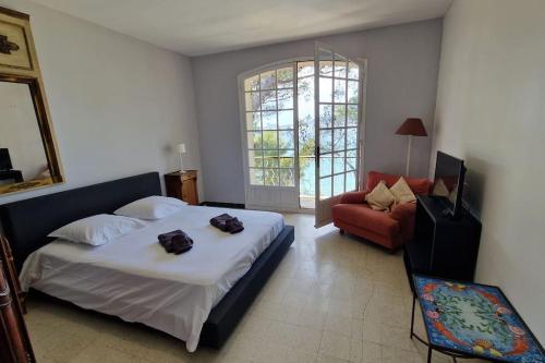 une chambre avec un lit, un canapé et une fenêtre dans l'établissement Grande maison climatisée piscine en bord de mer, à Saint-Cyr-sur-Mer