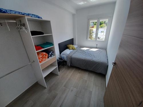 Habitación pequeña con cama y ventana en Apartamento Arrufat&Osorio, en Granada