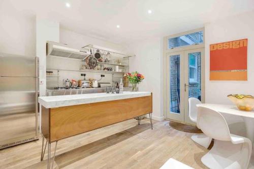 a kitchen with a large sink and a table at Eclectic family home in the heart of Notting Hill in London