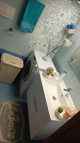 een badkamer met wastafel en wasmachine bij Che bella vita! in Monopoli