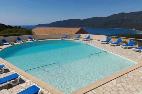 a large swimming pool with lounge chairs at Caseddu T2 N 14, Alba Rossa avec Piscine Chauffée in Serra-di-Ferro