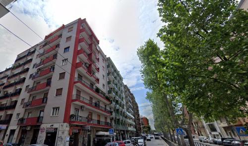 un edificio rojo y blanco en una calle de la ciudad en Repubblica Rooms, en Bari