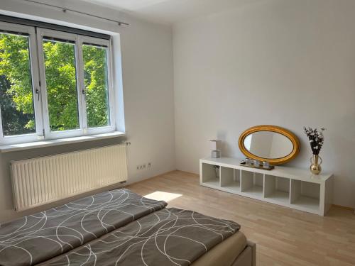 Schlafzimmer mit einem Bett und einem Wandspiegel in der Unterkunft Traumgarten in Traumlage - 25 Minuten ins Zentrum in Wien